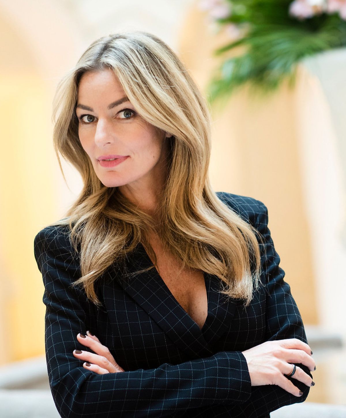 Woman with long hair in a stylish blazer.