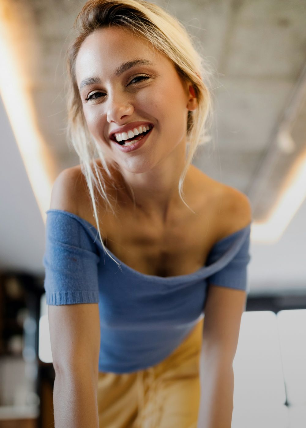 Model posing by window in neutral attire.