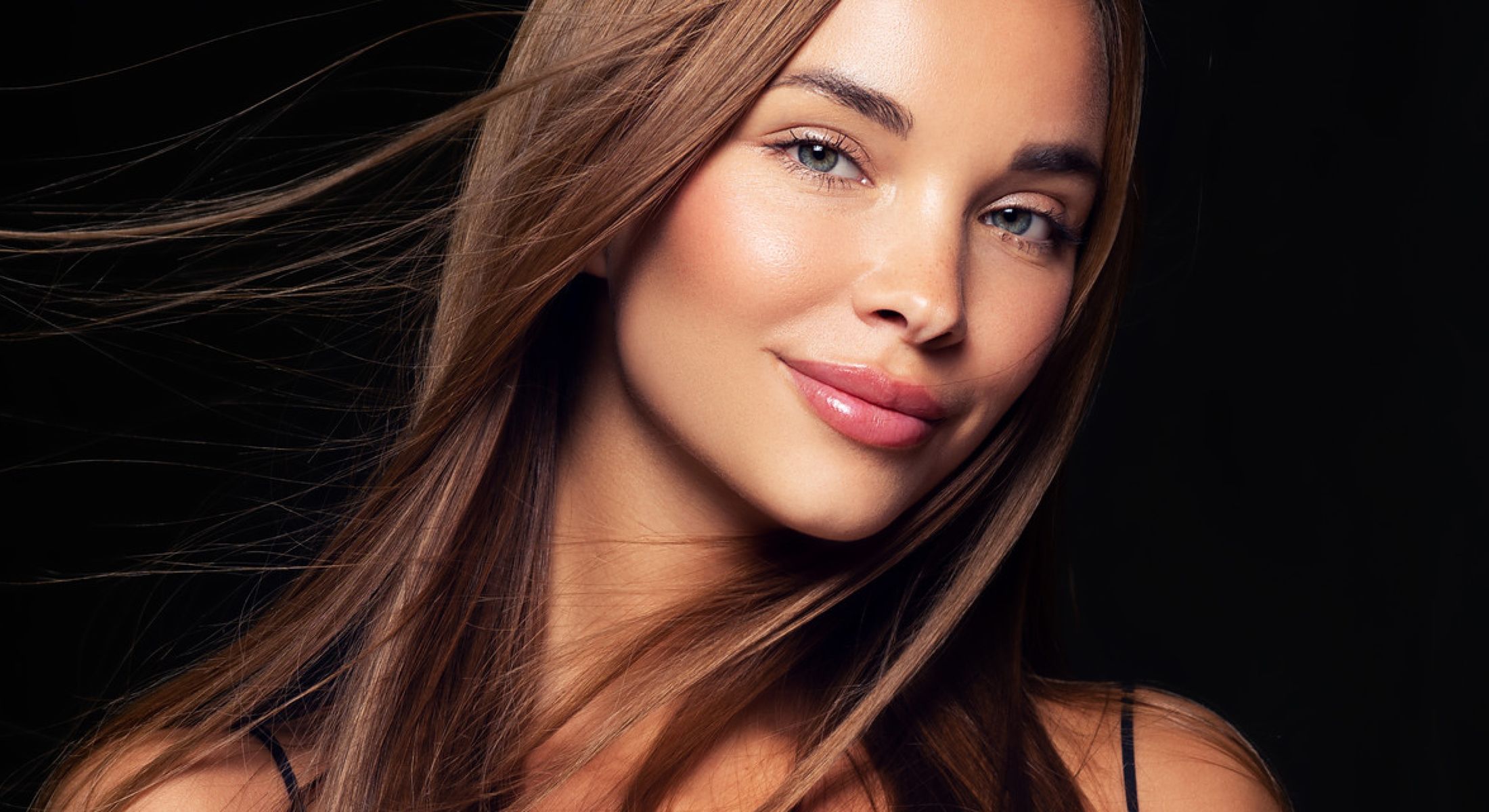 Woman with long hair smiling gracefully.